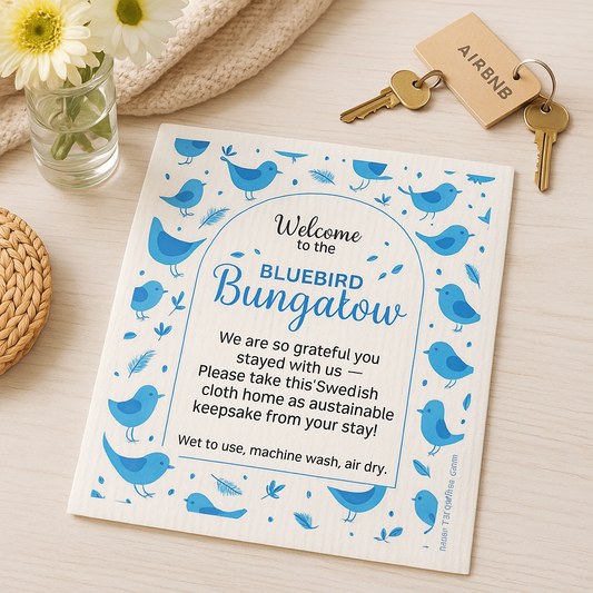 Welcome swedish cloth with blue birds and text on a table with keys and flowers